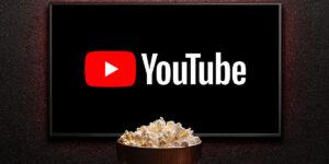 Logotipo de YouTube en un televisor inteligente. Televisor, tazón de palomitas de maíz.