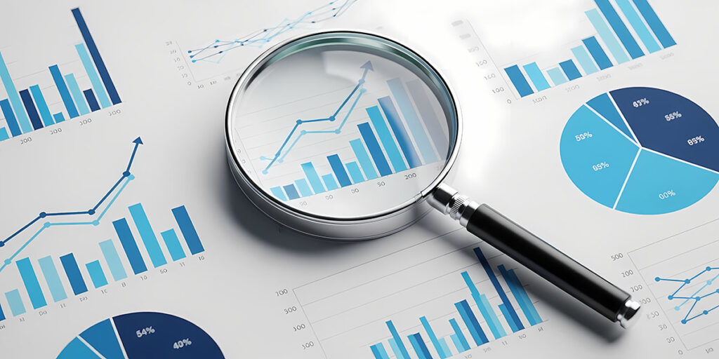 Fotografía de primer plano de gráficos y diagramas comerciales con una lupa, adecuada para ilustrar conceptos de análisis de datos y revisión financiera.