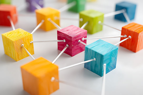 Una estructura de red formada por bloques de colores conectados entre sí, simbolizando la conexión y la interacción.