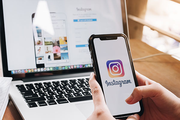 Una mujer sostiene un iPhone X de Apple con la aplicación Instagram en la pantalla en una cafetería. Instagram es una aplicación para compartir fotos en smartphones.