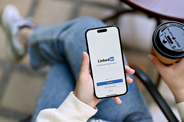 Imagen de primer plano de las manos de una mujer sosteniendo un teléfono inteligente con el logotipo de LinkedIn en la pantalla, inicie sesión o regístrese en la plataforma LinkedIn, iPhone con el logotipo de LinkedIn en la pantalla.