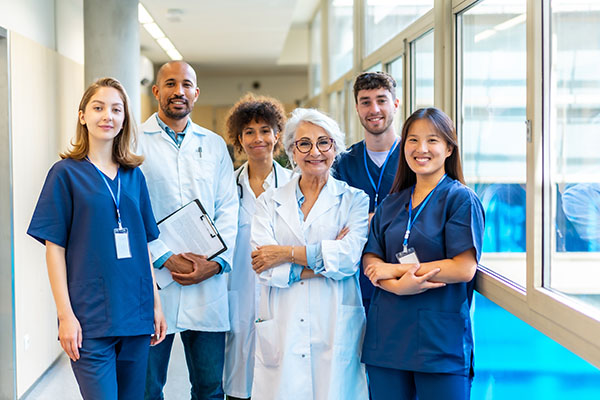 Médicos y enfermeras juntos en un pasillo de hospital, representando el trabajo en equipo y el profesionalismo en la atención médica.