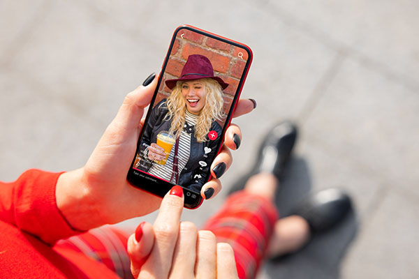 Mujer viendo contenido de redes sociales en su teléfono móvil.