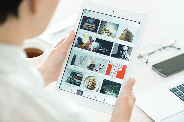 Persona mirando los tableros de la aplicación Pinterest en el moderno iPad Air blanco de Apple, que fue diseñado y desarrollado por Apple Inc. y fue lanzado el 1 de noviembre de 2013.