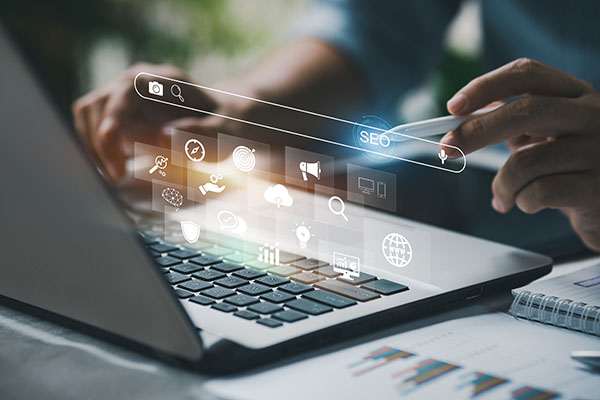 Persona que trabaja con una computadora portátil para administrar la optimización de motores de búsqueda: SEO con contenido de redes sociales y publicidad del sitio web.