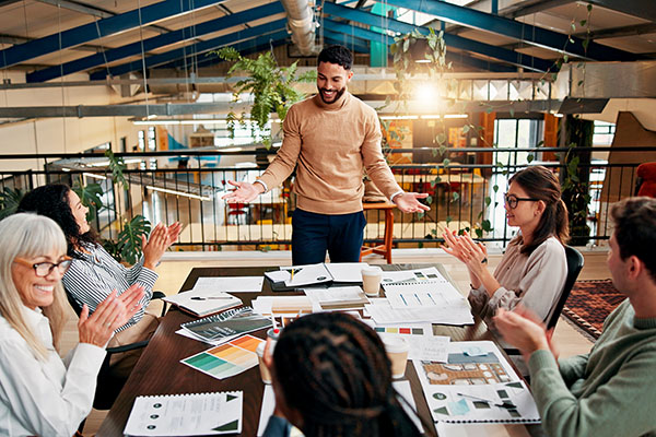 Documentación creativa, personas y aplausos en una reunión para el reconocimiento de la campaña, los objetivos de KPI y la aprobación de la marca. Agencia de diseño, arriba, y aplausos del equipo por el éxito de la presentación de marketing y la gestión del proyecto.