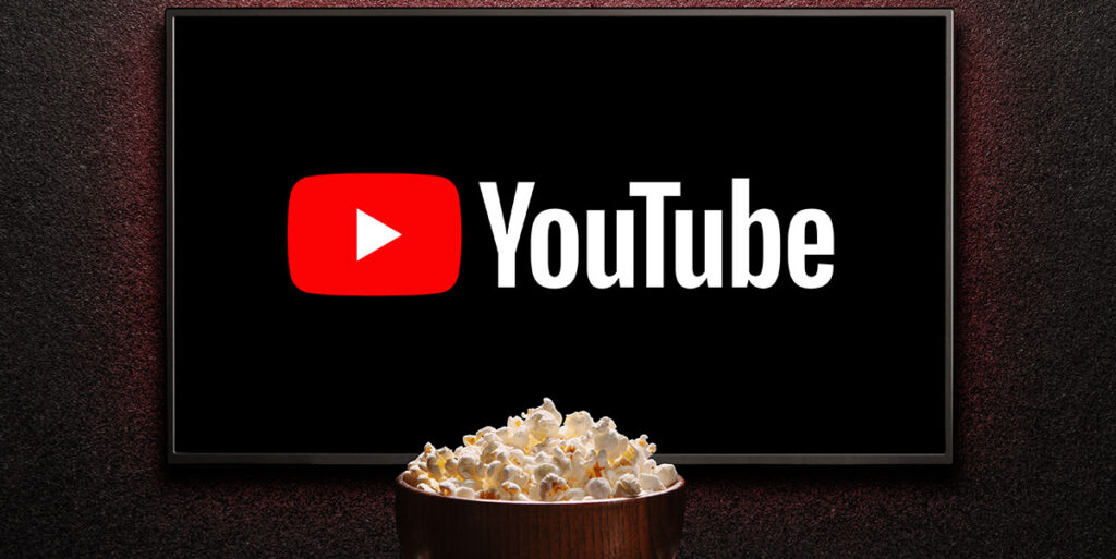 Logotipo de YouTube en un televisor inteligente. Televisor, tazón de palomitas de maíz.