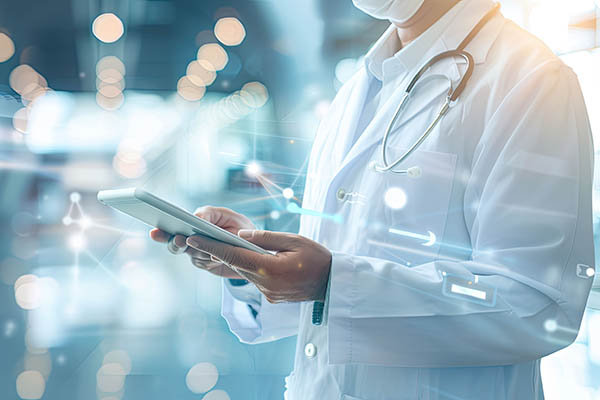 Médico profesional con bata blanca y estetoscopio utilizando una tableta digital en una clínica moderna.