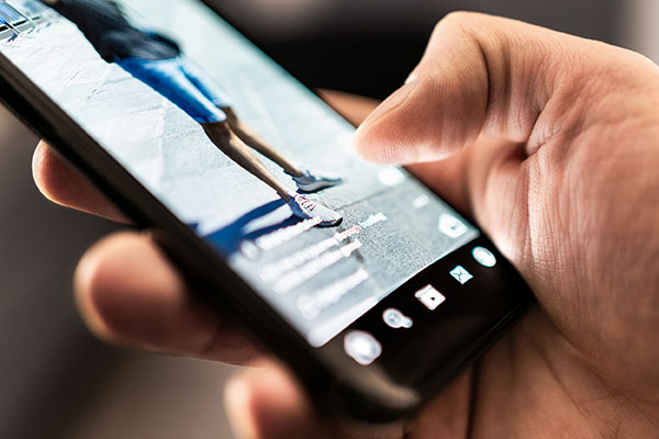 Vídeo viral corto en redes sociales. Contenido de tendencia en la pantalla del teléfono. Aplicación y plataforma para clips, transmisiones en vivo o campañas promocionales. Viendo entretenimiento digital en línea. Hombre con smartphone.